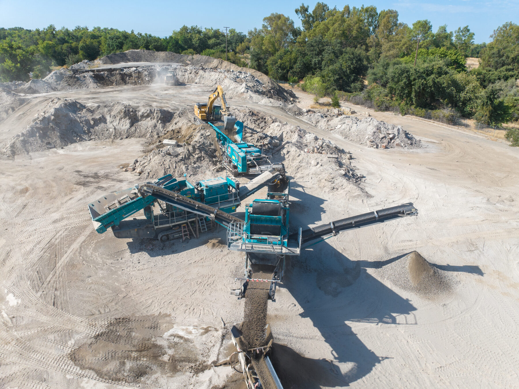 blue machines processing aggregate in a quarry