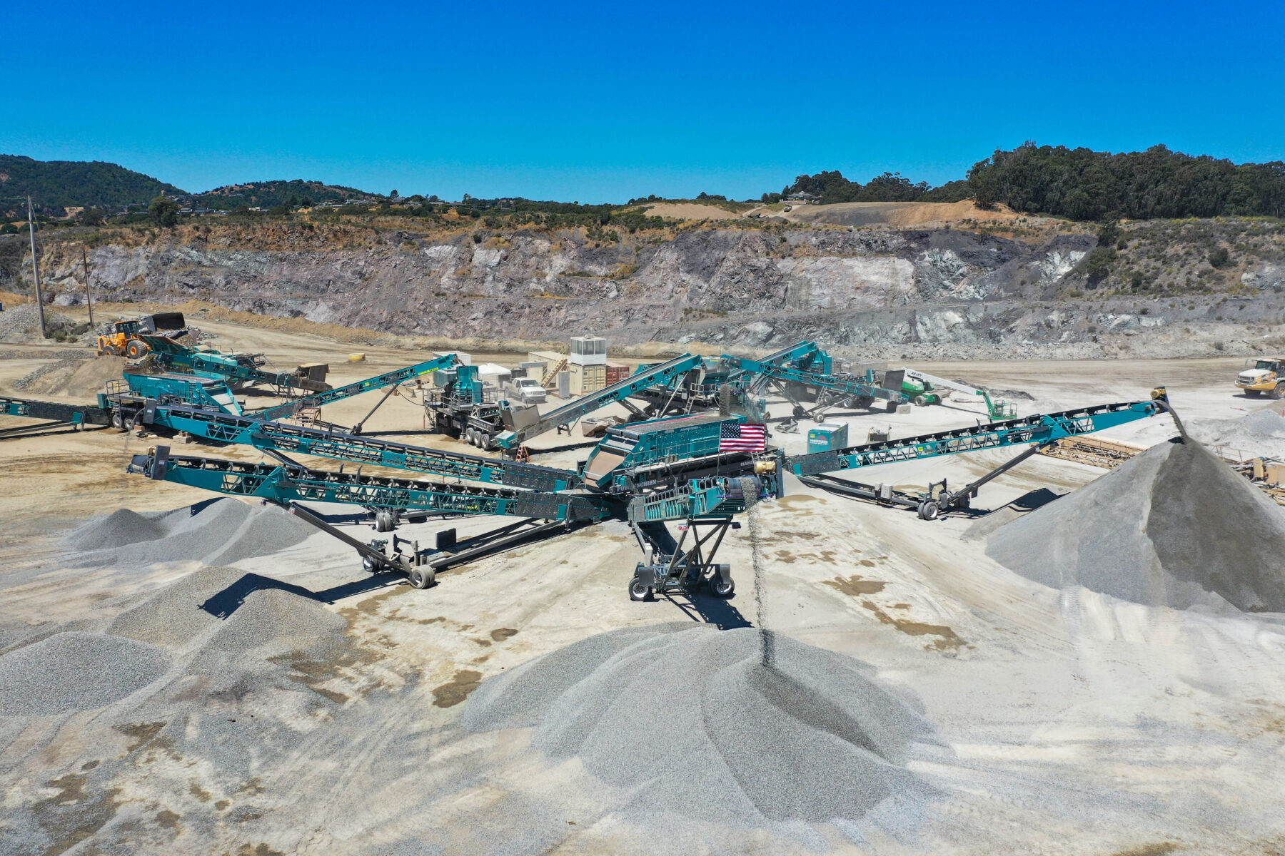 Rock quarry operation near the San Francisco Bay with Powerscreen machines processing aggregates.