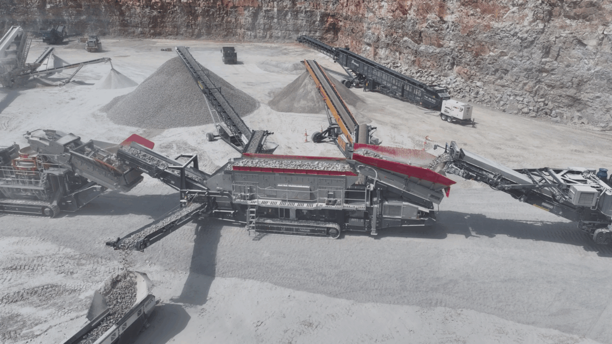 High-capacity MAGNA mobile crushing and screening plant at work in a quarry, efficiently processing rock into aggregate with multiple conveyors and stockpiles.