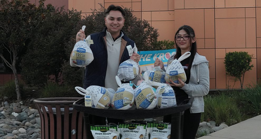 Man and a woman holding frozen turkeys as they donated 20 of them to the Salvation Army