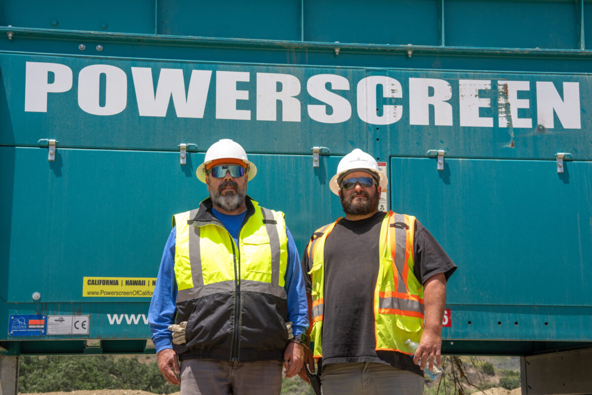 Two men in PPE in front of a powerscreen screener.