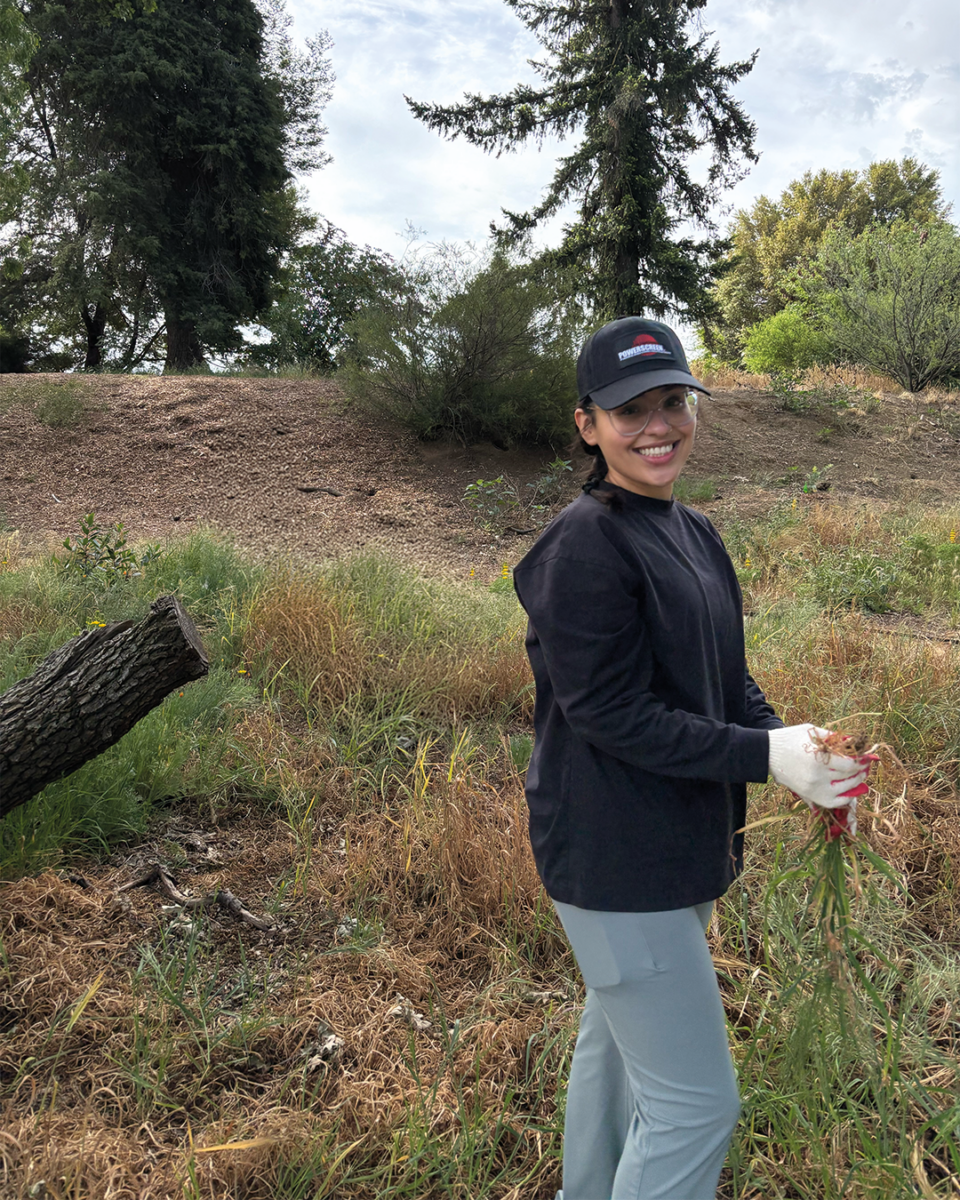 Mujer sonriendo mientras arranca malas hierbas
