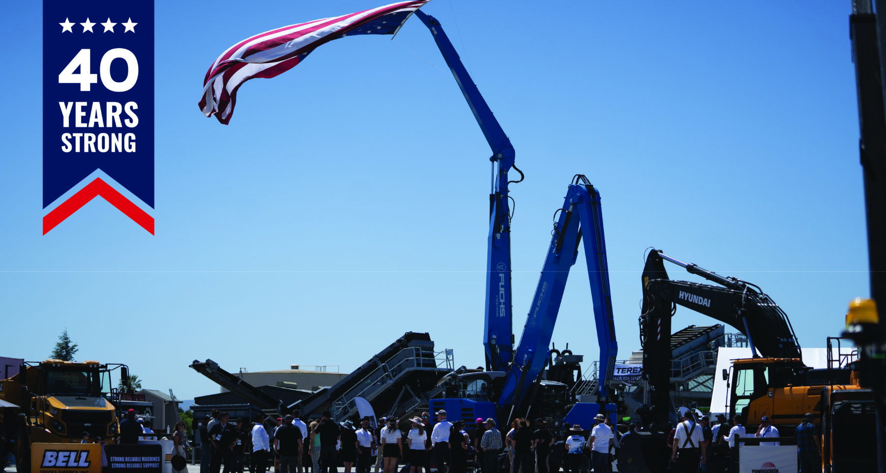 Powerscreen XPO event with guests standing under an American flag held up by a Fuchs material handler